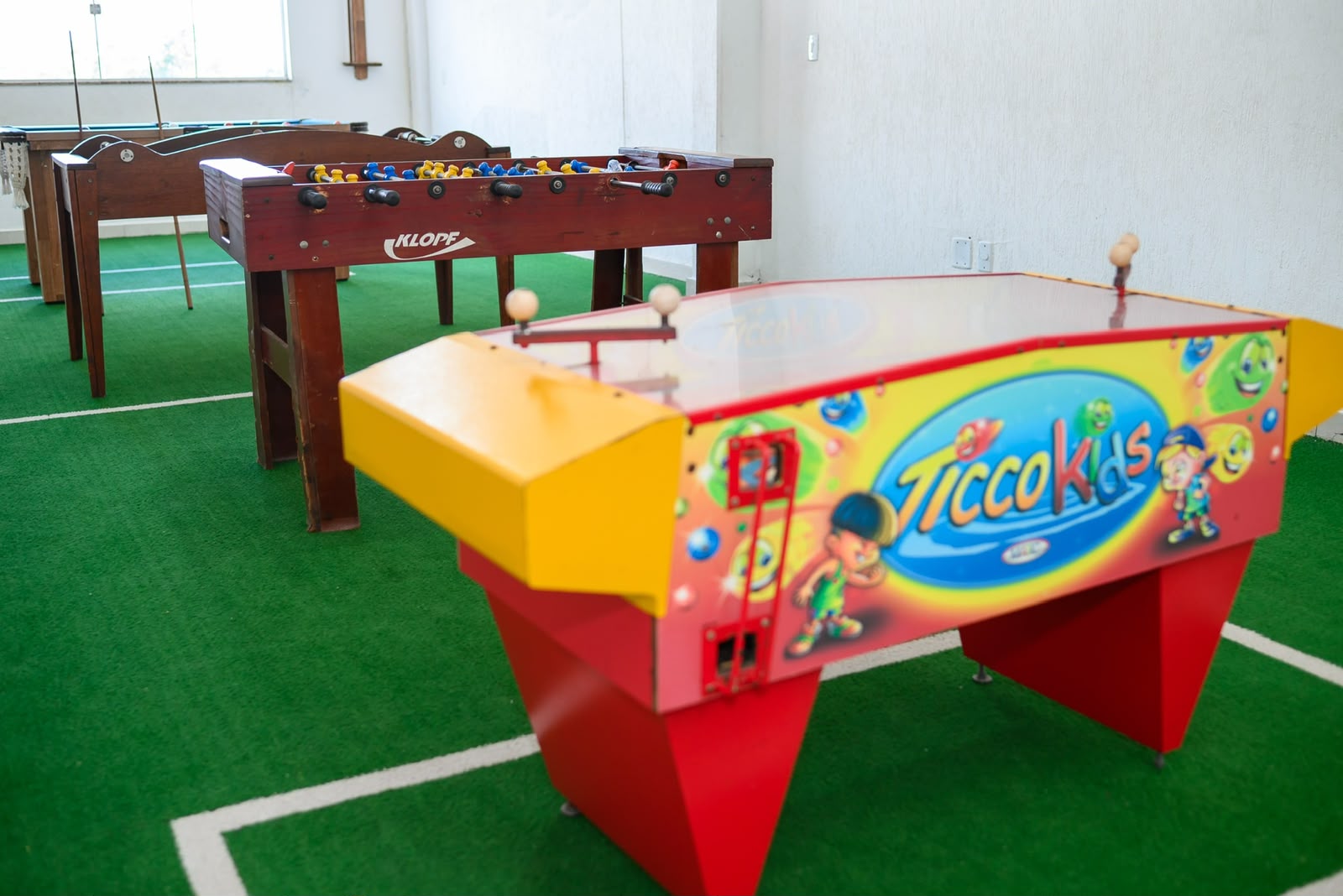 Espaço de jogos com pebolim, aerohockey e sinuca